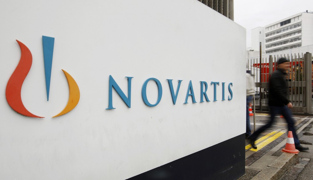File photo of a man walking past the logo of Swiss drugmaker Novartis AG in front of a plant in Basel