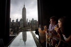 People sit and eat hot dogs and look at the Empire State Building after a hot dog eating competition was moved indoors due to bad weather on Independence Day in the Manhattan borough of New York