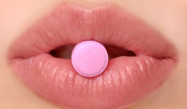 alt="woman taking the pink pill"