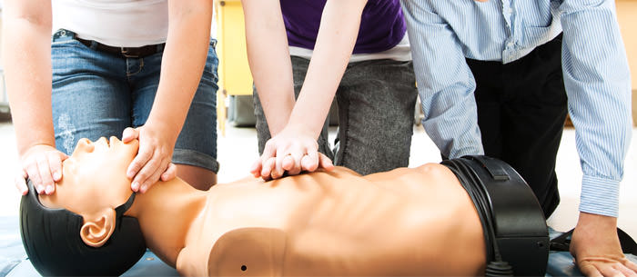 alt="Volunteers Learning CPR procedure on a dummy"