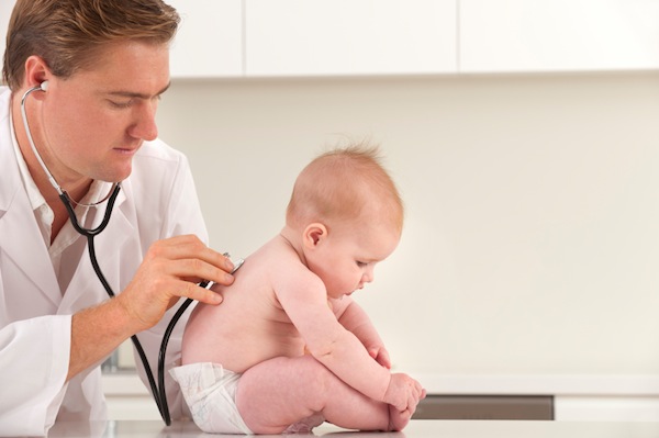 "doctor checking infant's breathing rate"
