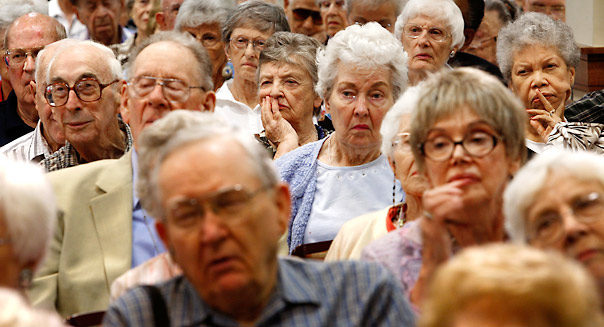 alt="SPRINGFIELD, VA - AUGUST 25:  Residents listen during a health care forum at Greenspring Retirement Community August 25, 2009 in Springfield, Virginia. Congressional members from across the country have returned to their own district to listen to voters' opinions on healthcare reform.  (Photo by Alex Wong/Getty Images)"