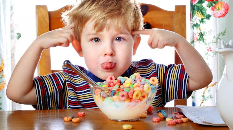 alt= little boy spills colorful cereal bowl