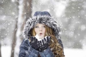 Young girl playing with snow outdoors