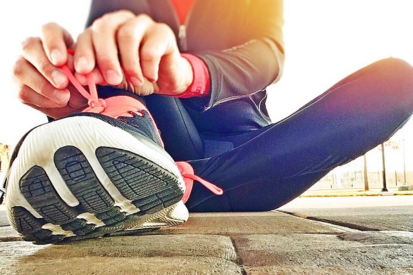 woman tying running shoes for stroke prevention 