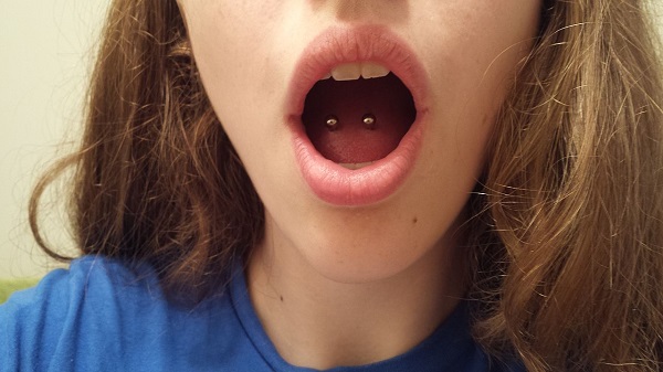 Girl showing her tongue piercings