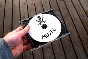 Person holding CD containing pirated music